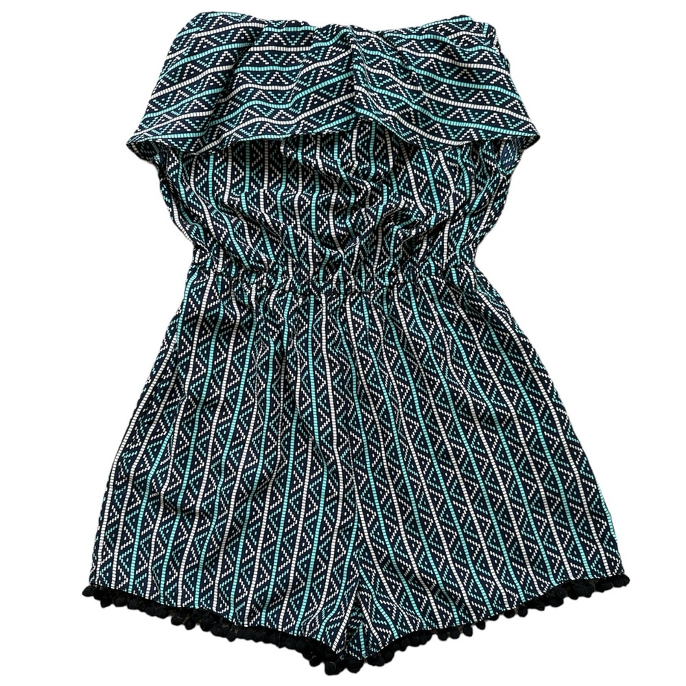 Strapless multi-color romper with ruffle bust line and pompom fringe on shorts.